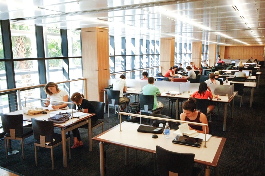 students studying at tables in Smathers Library West, one of the largest libraries on campus